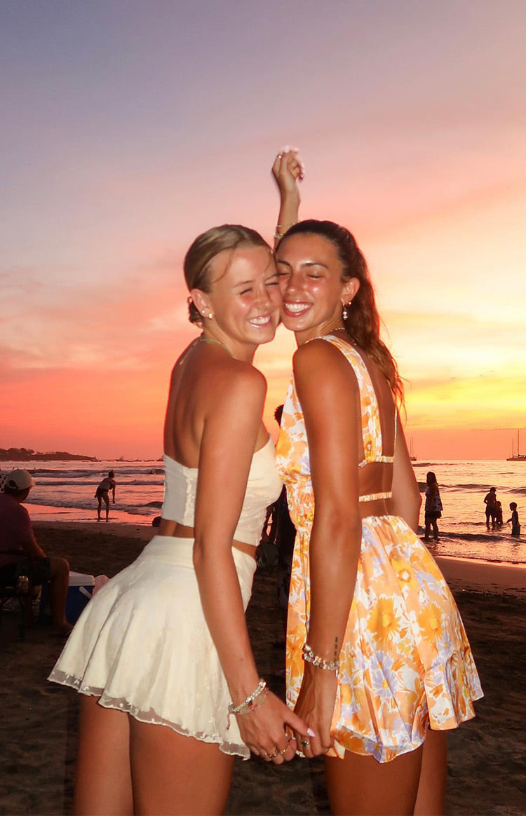 Side view of a light yellow strapless mesh top with a straight back