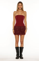 Front view of a burgundy strapless mini dress with a smooth fitted bodice and a shaggy fur skirt