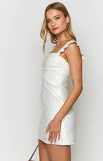 Side view of a white mini dress with ruffled shoulder straps and ruched bodice detail