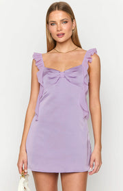 Lilac satin mini dress featuring a sweetheart neckline, a large bow detail on the bust, and ruffled straps