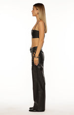 Side view of a black PU leather crop top with thin spaghetti straps and a gathered front