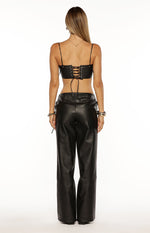 Rear view of a black PU leather crop top with a lace-up back detail and thin spaghetti straps