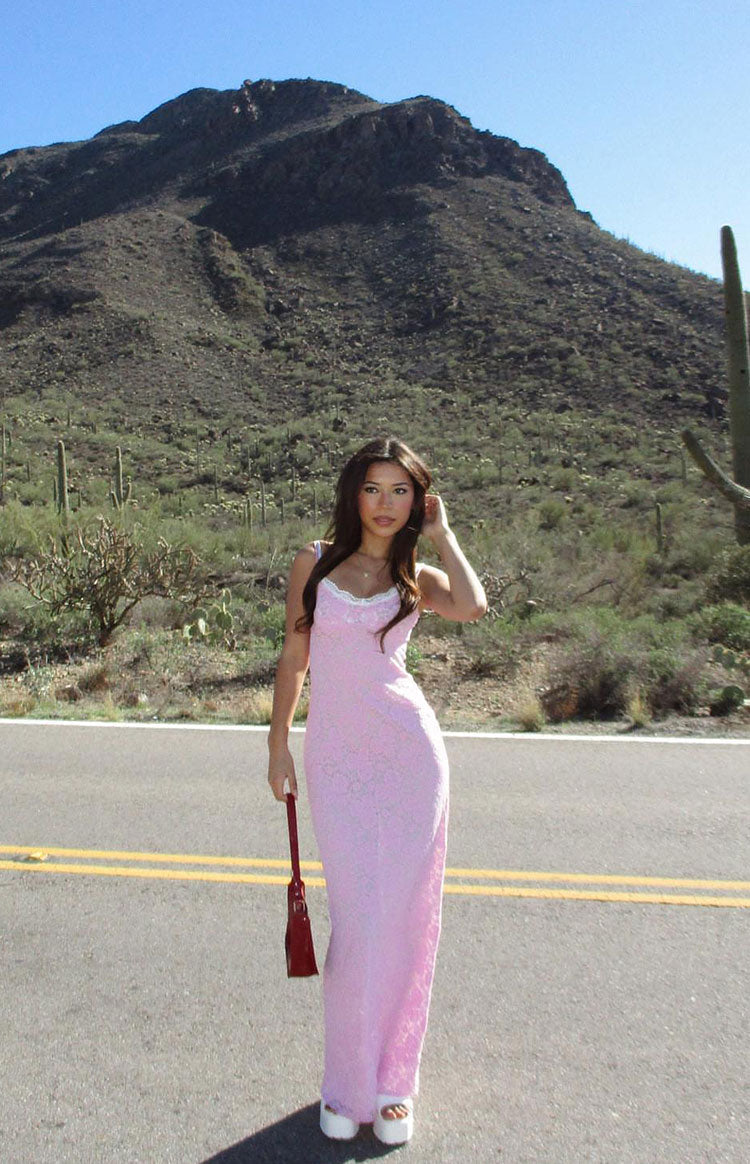 Front view of a pink lace maxi dress with a fitted silhouette and white lace trim on the scoop neckline