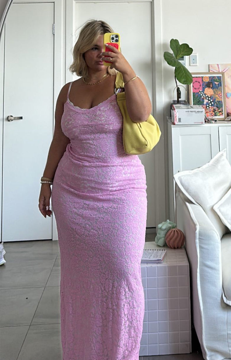 Full length view of a pink lace maxi dress with a fitted silhouette and white lace trim on the neckline