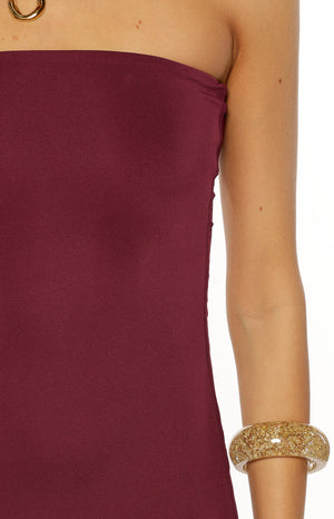 Close-up of the plum strapless neckline of the midi dress, showing the fine knit fabric texture