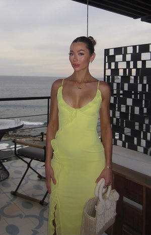 Front view of a yellow maxi dress with a ruffled V-neck and a high side slit