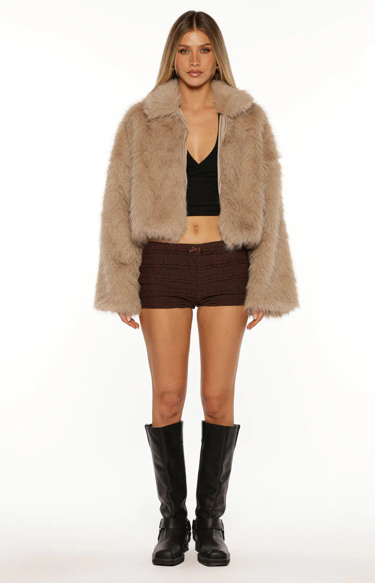 Front view of the light brown cropped faux fur jacket, open to reveal the zipper and plush texture