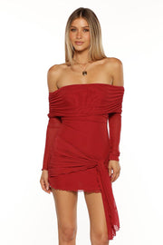 Red off-the-shoulder mini dress with ruched bodice, sheer long sleeves, and a knotted draped skirt