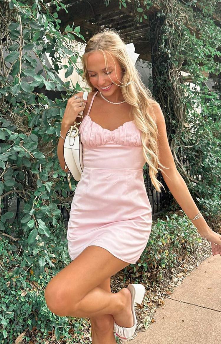 Light pink mini dress with a ruched bust, thin spaghetti straps, and a fitted silhouette