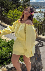 Yellow Bardot mini dress with ruffled off-shoulder neckline, voluminous long sleeves, and elasticated waist and hem