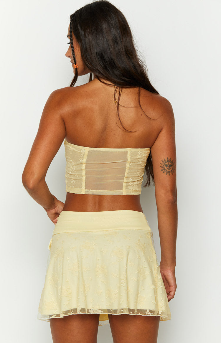 Back view of the yellow strapless mesh corset top with sheer mesh paneling and ruched details