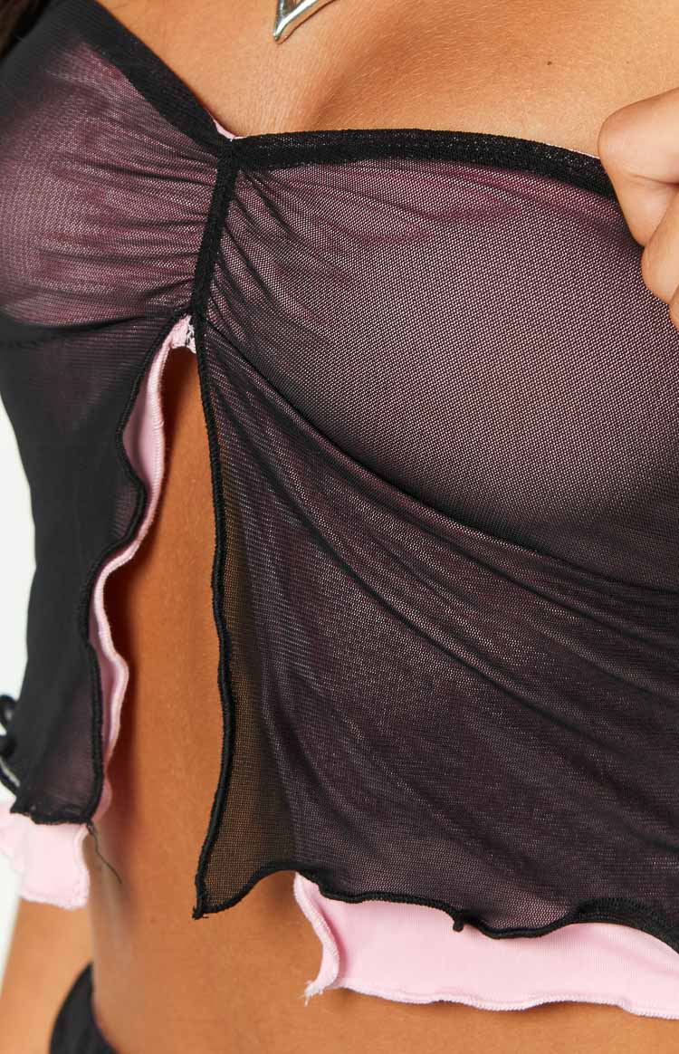 Close-up of the ruched black mesh fabric and split opening with ruffled pink lining on the tube top
