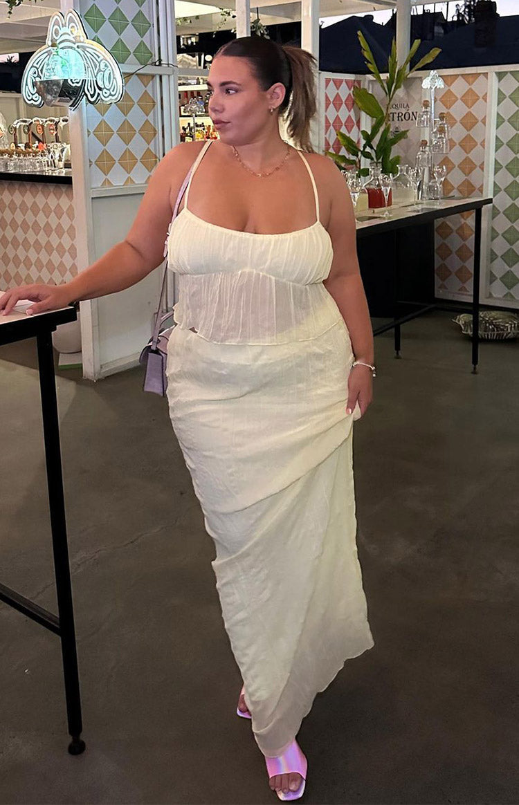 Rear view of a yellow cami top with thin adjustable spaghetti straps and a gathered back