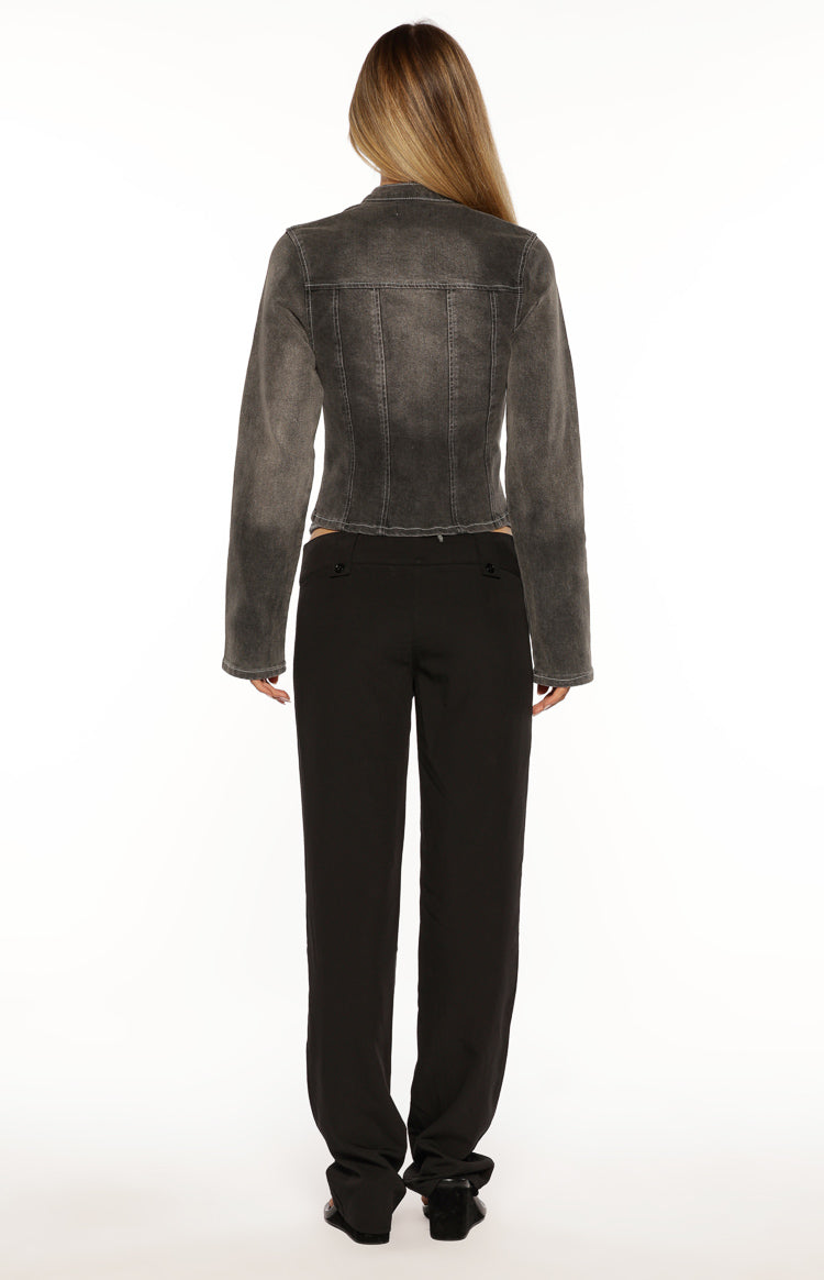 Rear view of black low waist pants with a straight leg and two button details on the back waistband