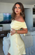 Side view of a primrose yellow satin mini dress with ruched off-shoulder sleeves and a fitted waist